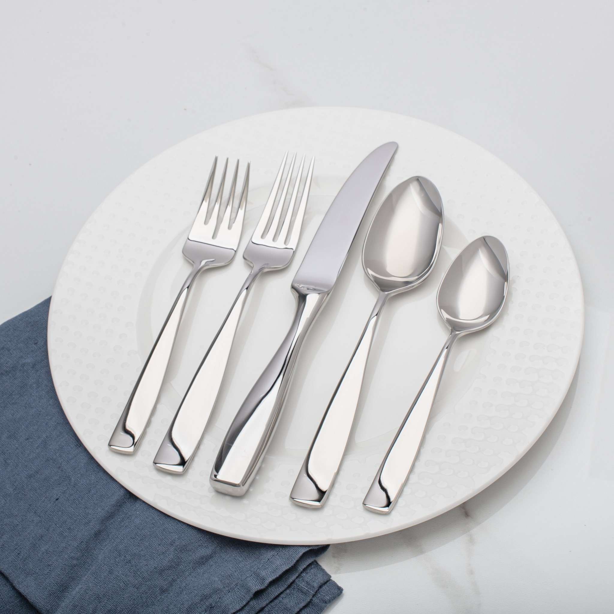 ustensiles inox 20 pièces alignés table
