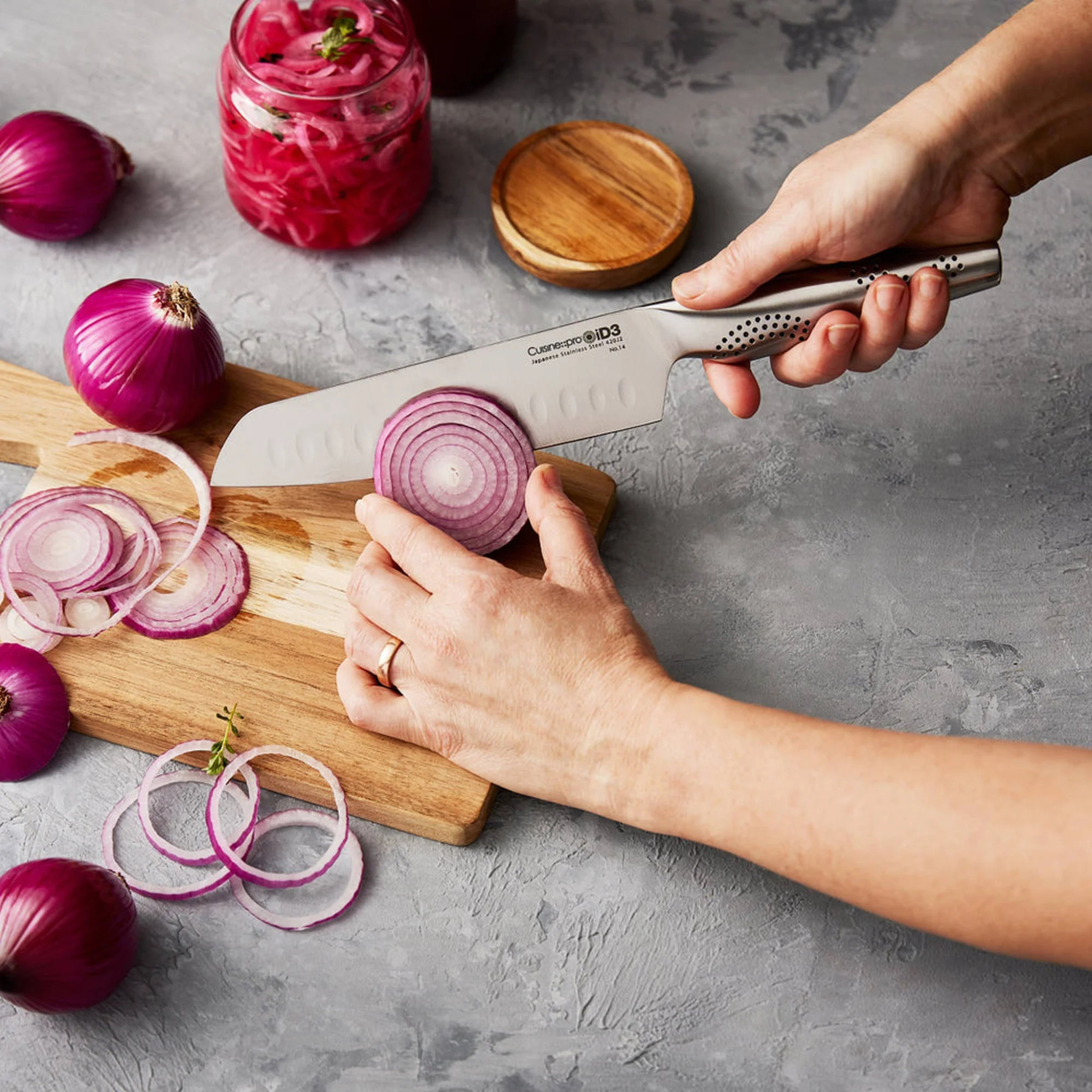 couteau santoku utilisé pour couper légumes sur planche